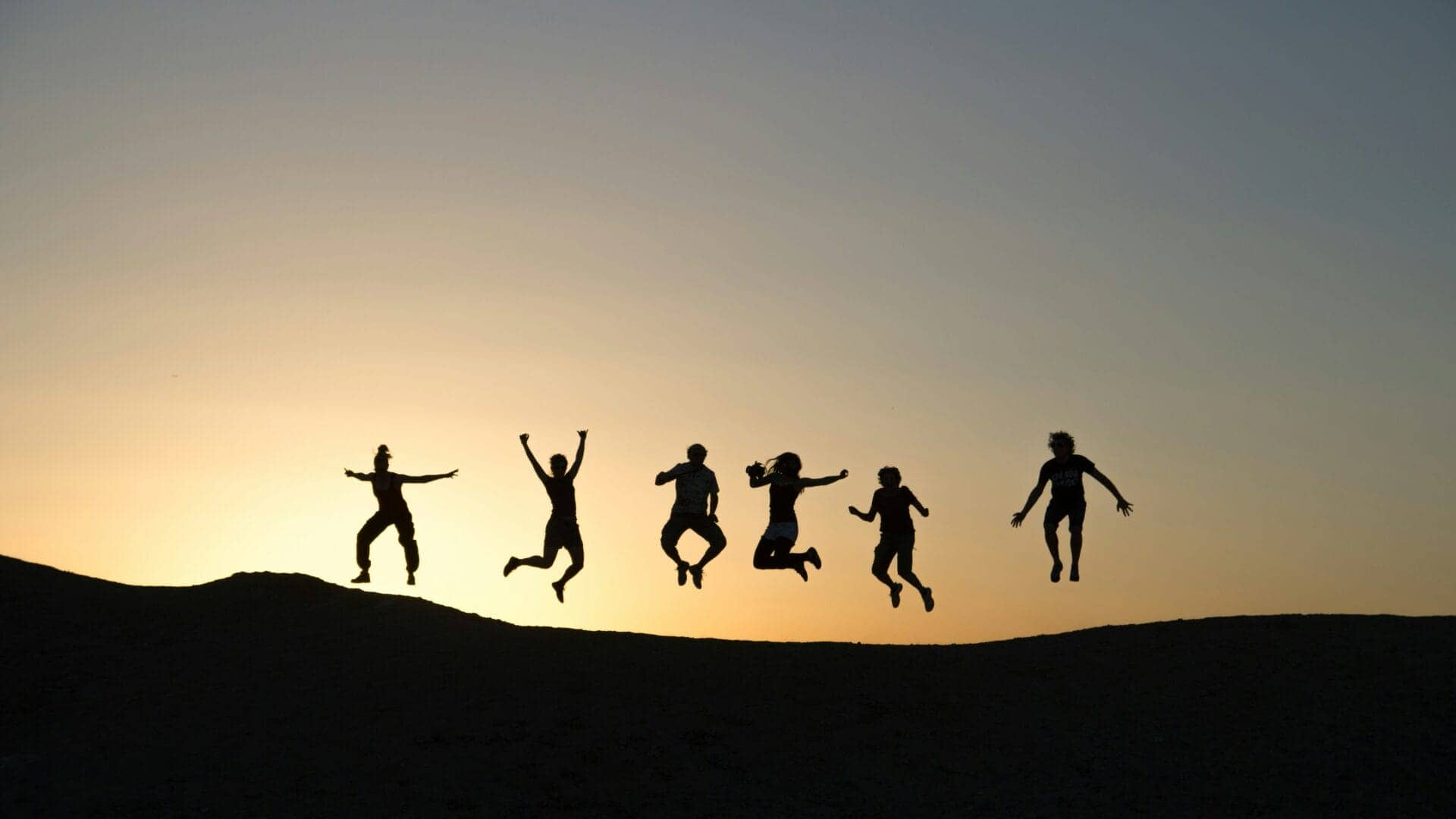 girls jumping on hill