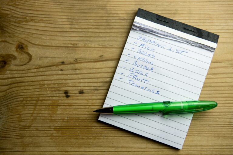 shopping list on paper with pen on top