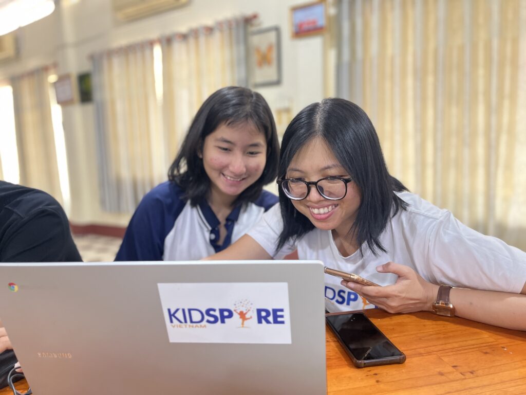 girls looking at laptop and smiling