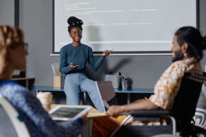 woman talking to colleagues in front of projection screen