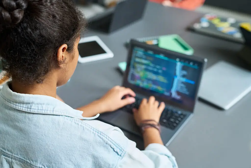 young woman coding on laptop